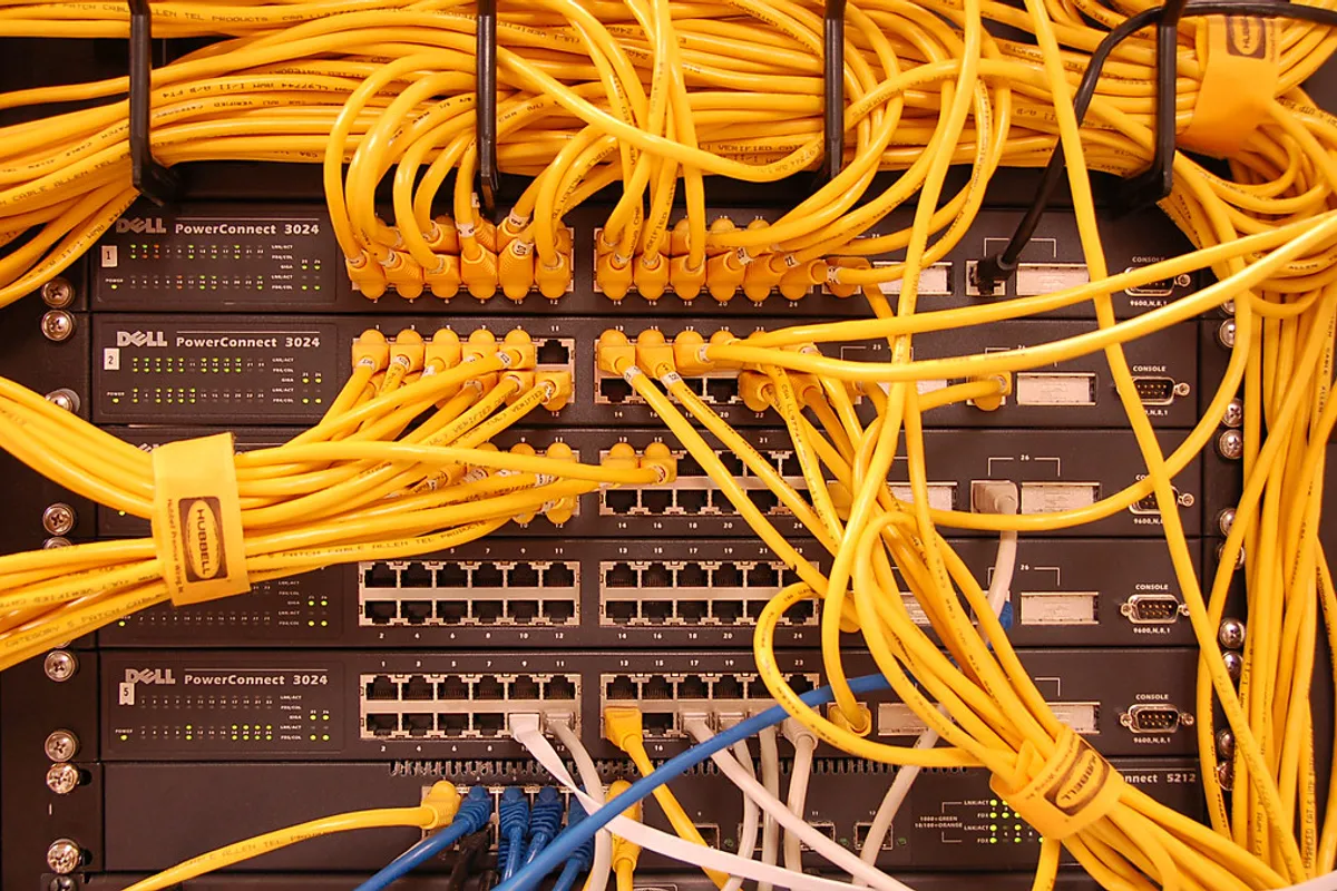 Kable sieciowe podłączone do switchy w szafie rack